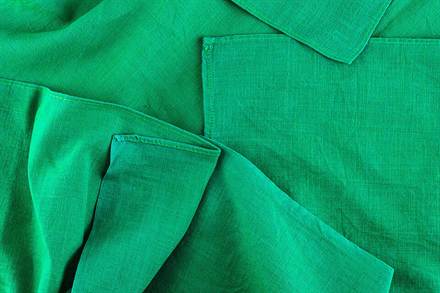 Deep, even folds running through a finished green textile