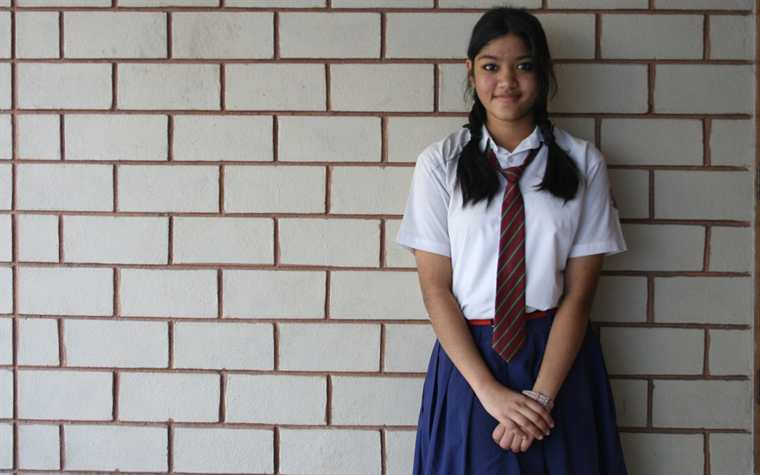 A school student wearing a neatly pressed uniform